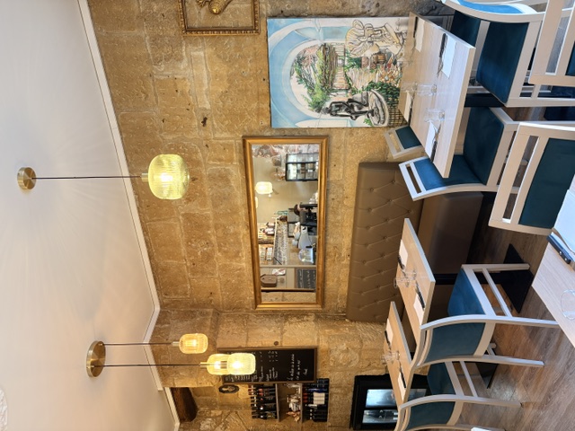 Salle en pierre avec banquette et suspensions dorées