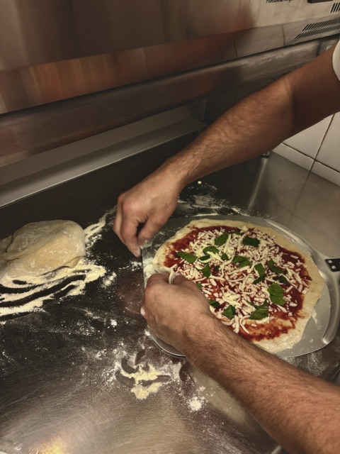 Pizza garnie à la main avant cuisson